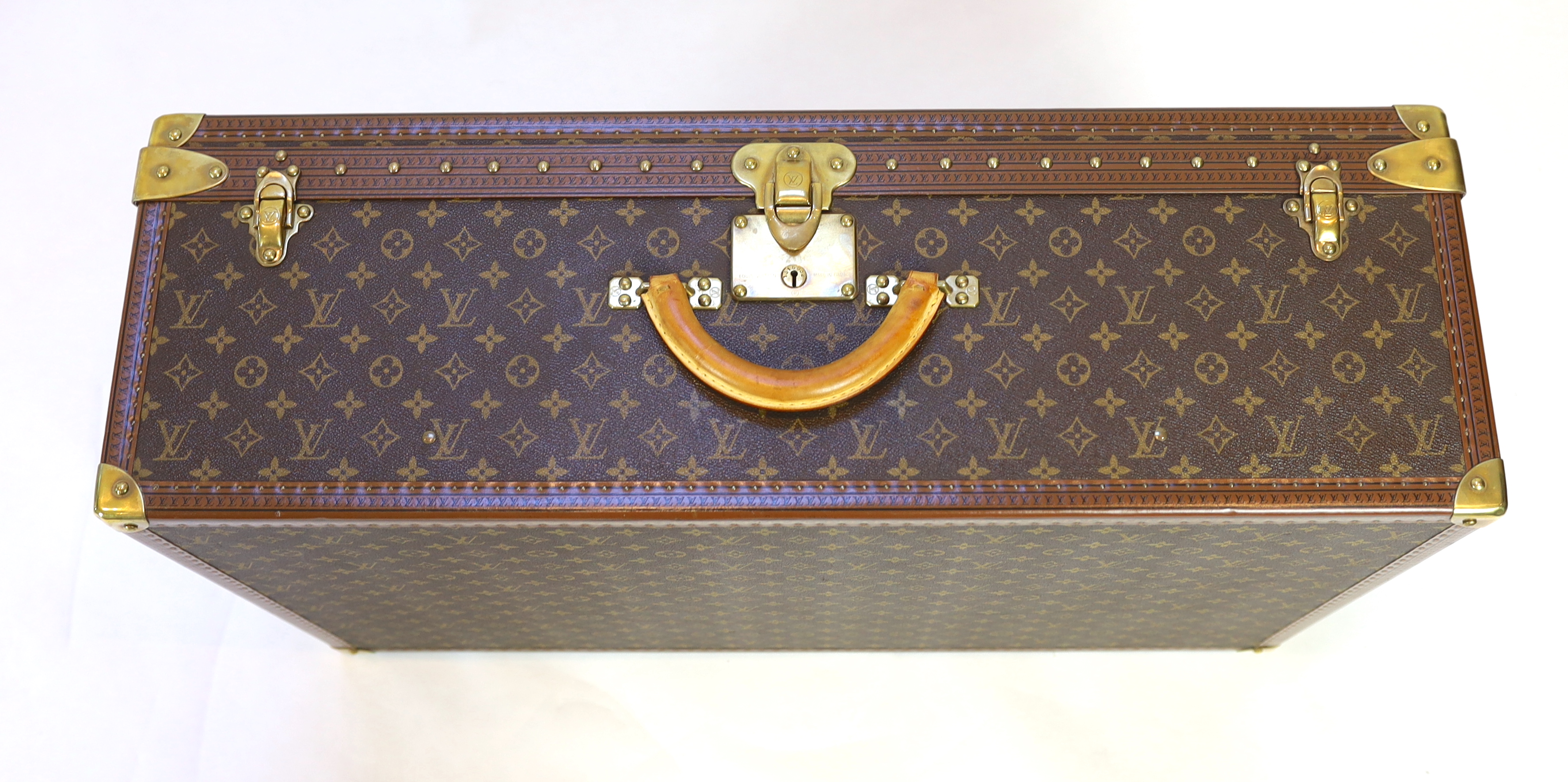 A Louis Vuitton monogrammed canvas and tan leather suitcase, 81cm wide, 26cm deep, 52cm high